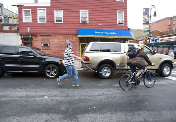 Участник массового нью-йоркского флешмоба инсценирует погоню невидимой собаки за велосипедом