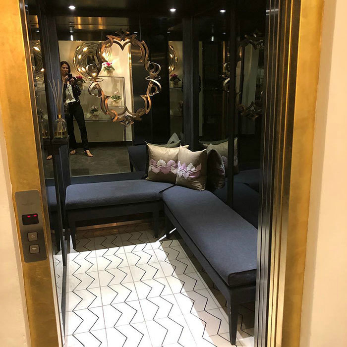 Лифт с зеркальной стеной и диванчиком.