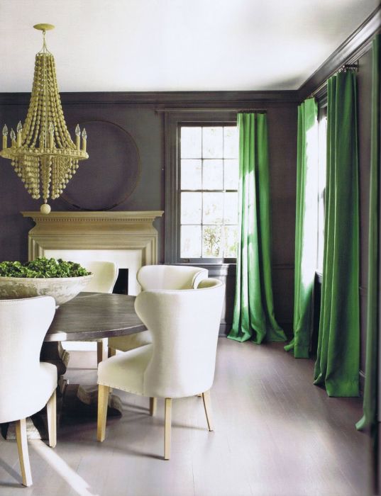 Нефритовые шторы разбавляют серый интерьер гостиной. 