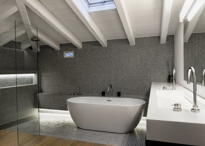 Серые стены из мелкой мозаики прекрасно смотрятся в ванной комнате. 