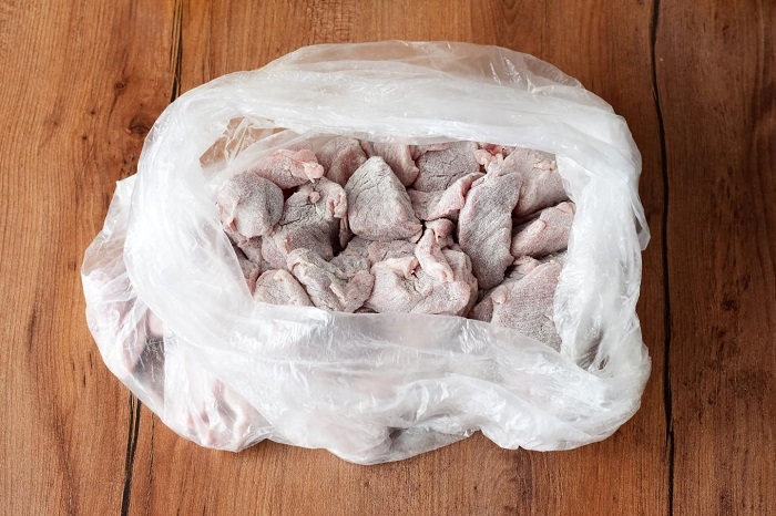 Положите кусочки мяса в пакет с мукой и встряхните