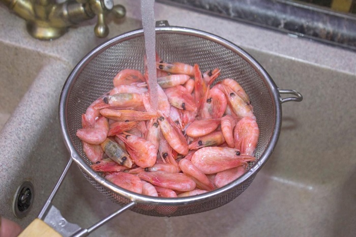 Разморозьте креветки под струей холодной воды. / Фото: mrfilin.com