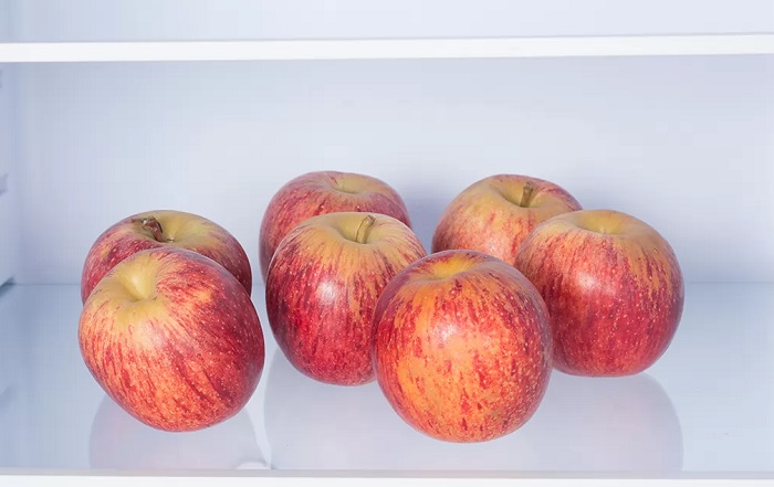 Красные яблоки на полке в холодильнике. / Фото: boombate.com