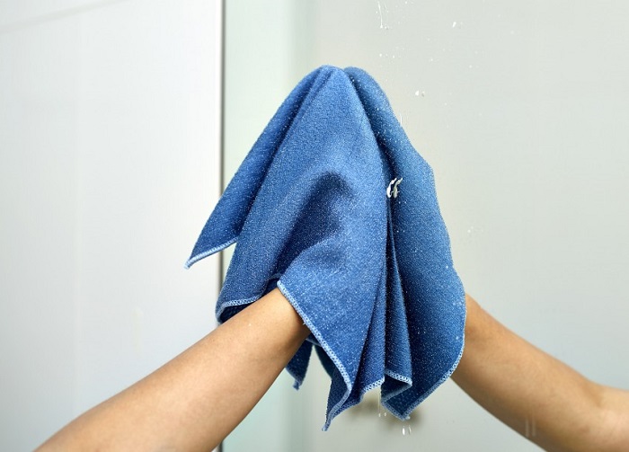 Влажная салфетка растирает пыль по зеркалу. / Фото: novinkimebeli.ru