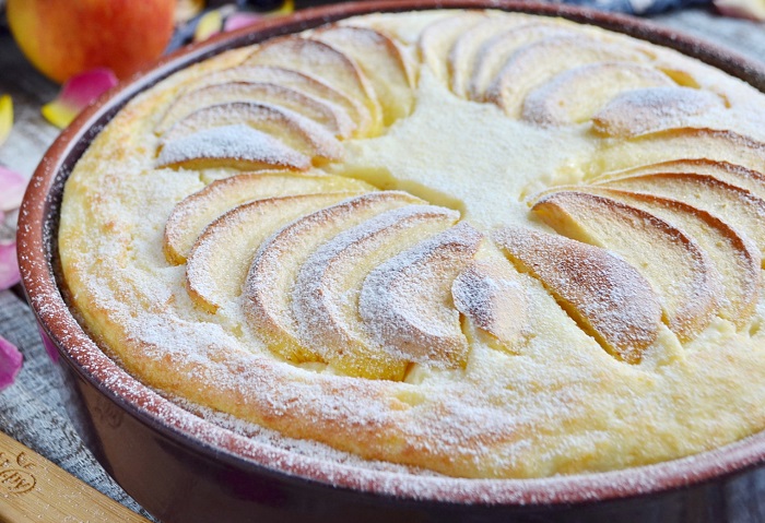 Украсьте пирог слайсами яблок и сахарной пудрой