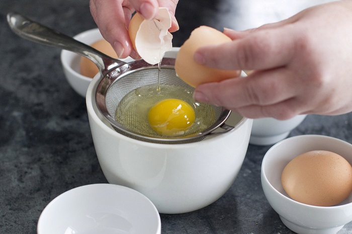Поставьте ситечко в миску и вбейте в него яйцо. / Фото: pinterest.com