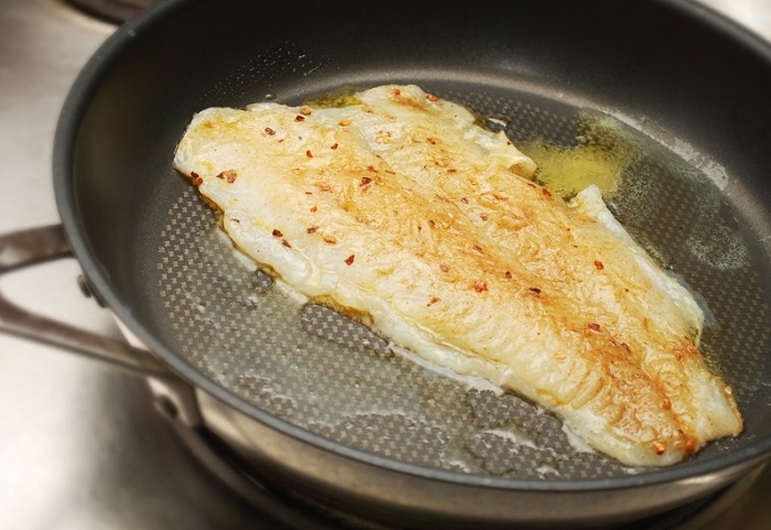 Когда рыба почти готова, добавьте в сковороду сливочного масла. / Фото: povar.ru