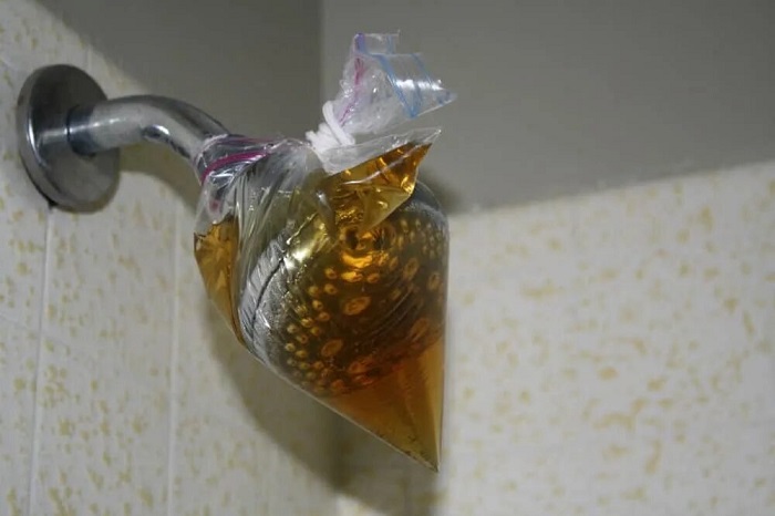 Наденьте на лейку пакет с уксусом