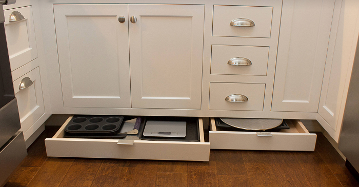 Под кухонными шкафчиками удобно хранить противни, формы для выпечки. / Фото: santehkrug.ru