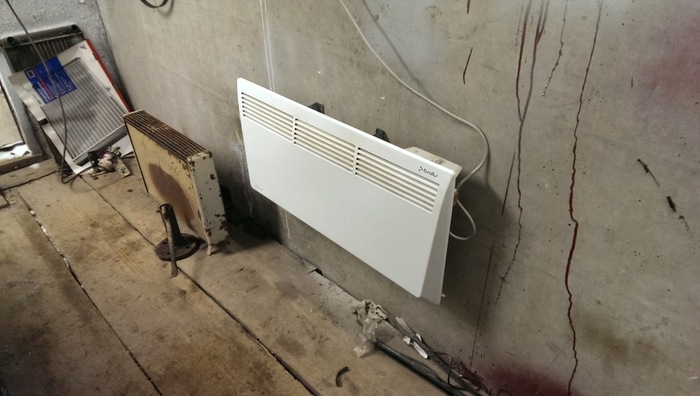 Обогреватель, висящий на стене в гараже Обогреватель, висящий на стене в гараже