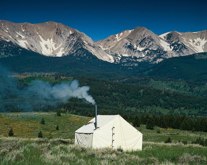 Палатка с двумя скатами на фоне горного пейзажа