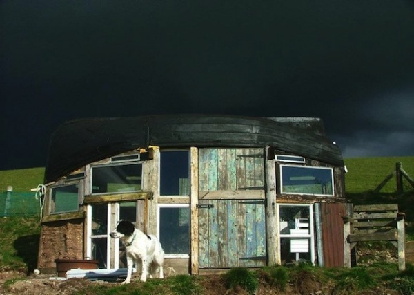 Дом из окон и дверей с лодкой вместо крыши 