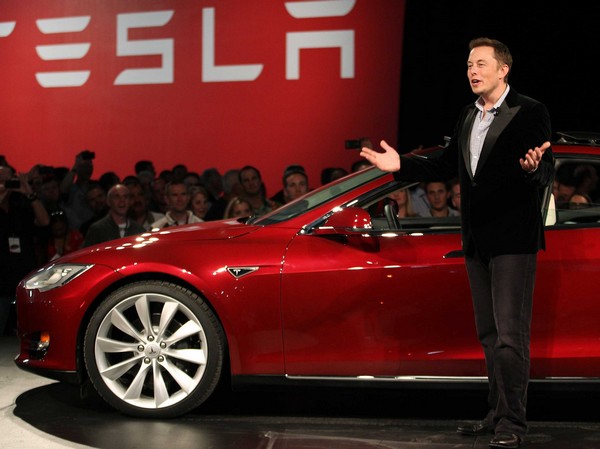 Илон Маск на фоне электромобиля Tesla