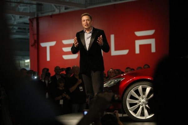 Илон Маск на фоне электромобиля Tesla