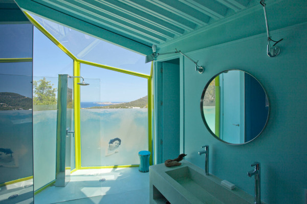 Интересный дизайн ванной комнаты с прозрачной душевой кабиной и панорамными окнами.