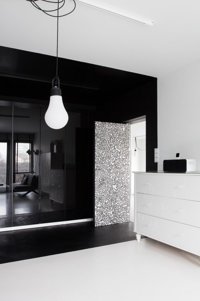 Черный зеркальный шкаф на фоне безукоризненно белых стен.