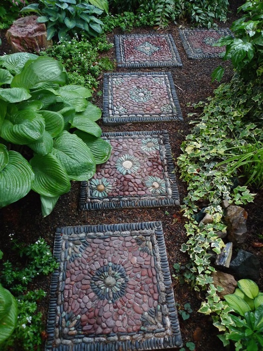 Садовую дорожку из скучных бетонных плит можно легко декорировать при помощи разноцветной речной гальки.