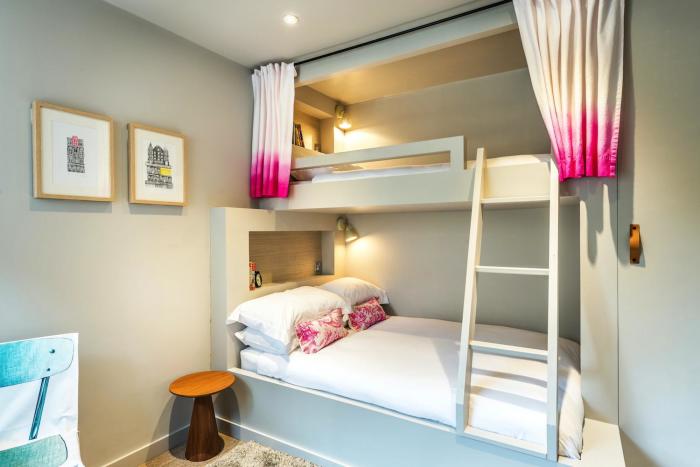 При выборе многоярусной кровати в небольшой спальне стоит обратить внимание на наличие встроенных систем хранения.