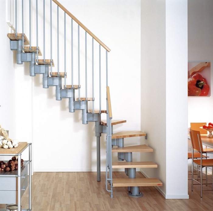 Лестница со ступенями, выполненными из лакированной древесины, и лаконичными металлическими перилами идеально вписалась в интерьер загородного дома.