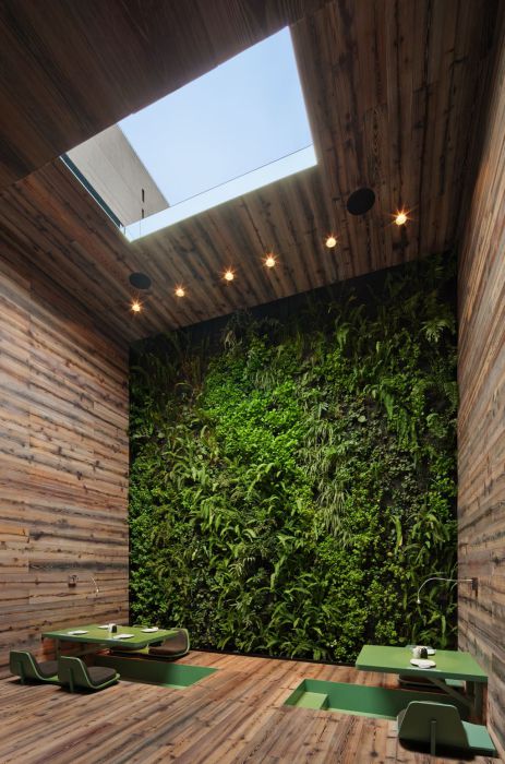 Стол в зеленых тонах и цветущая стена создают невероятно расслабляющую атмосферу.