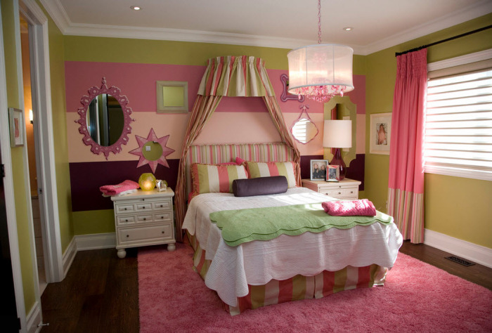 Невероятно девчачья спальня с кроватью с балдахином и яркими стенами.