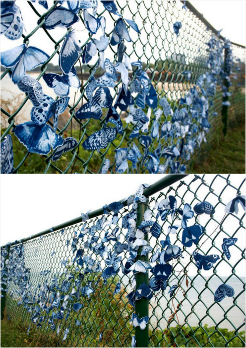 Забор, украшенный тканевыми бабочками.