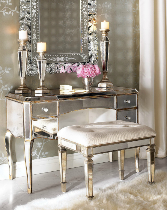 Оригинальный столик, украшенный металлическими пластинами и зеркало в массивной серебряной раме.