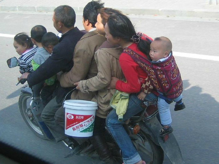 Огромная семья на маленьком мотоцикле.