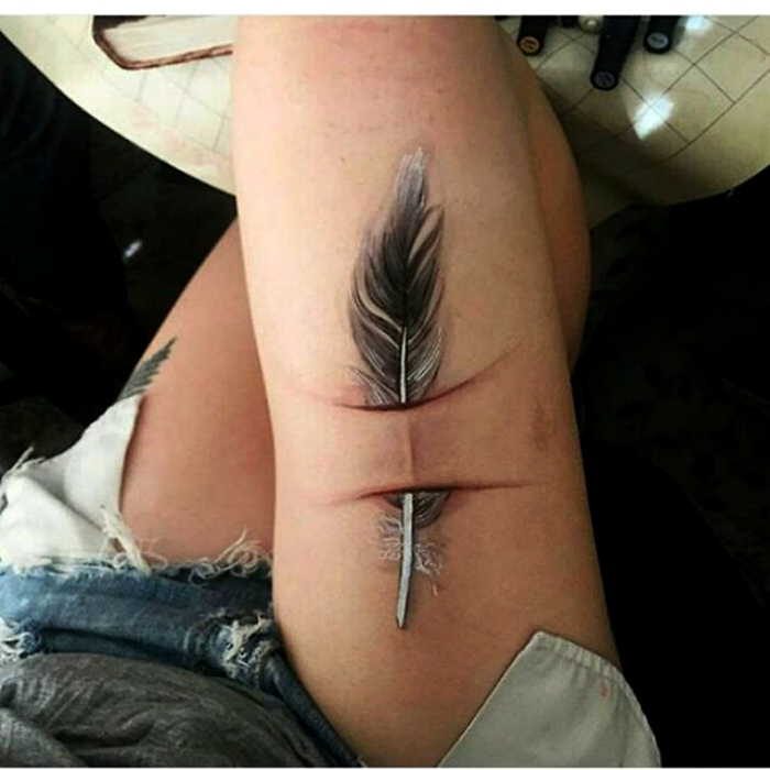 Объемная татуировка с изображением пера.