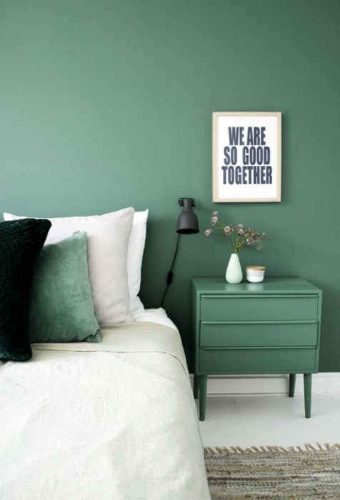 Спальня с модными зелеными стенами.