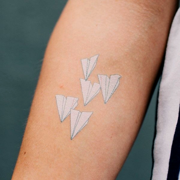Татуировка с изображением бумажных самолетиков.
