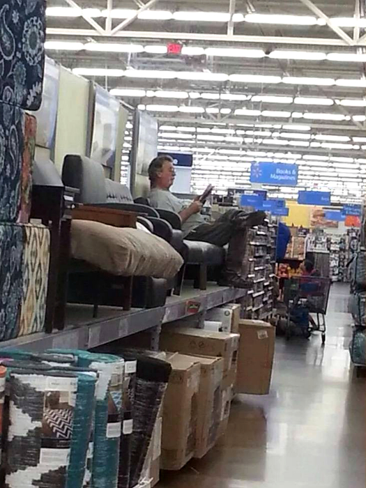 Мужчина в мебельном магазине тестирует кресло.