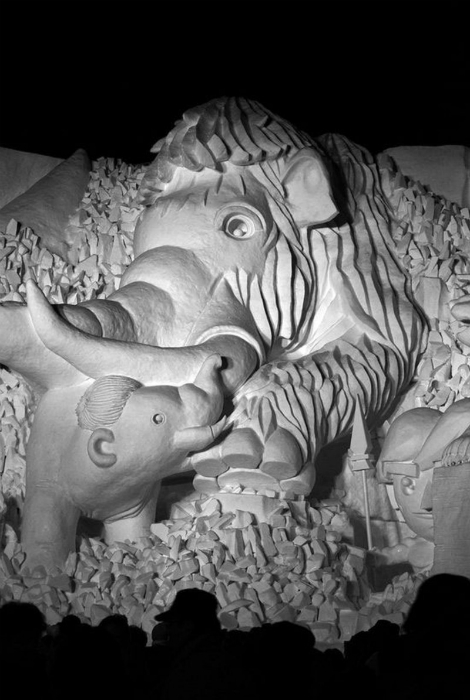 Снежная скульптура, изображающая мамонтенка и его маму.