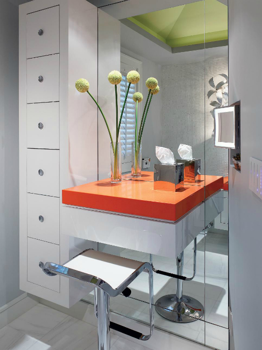 Современный туалетный столик с яркой оранжевой столешницей, простым дизайном и огромным зеркалом.