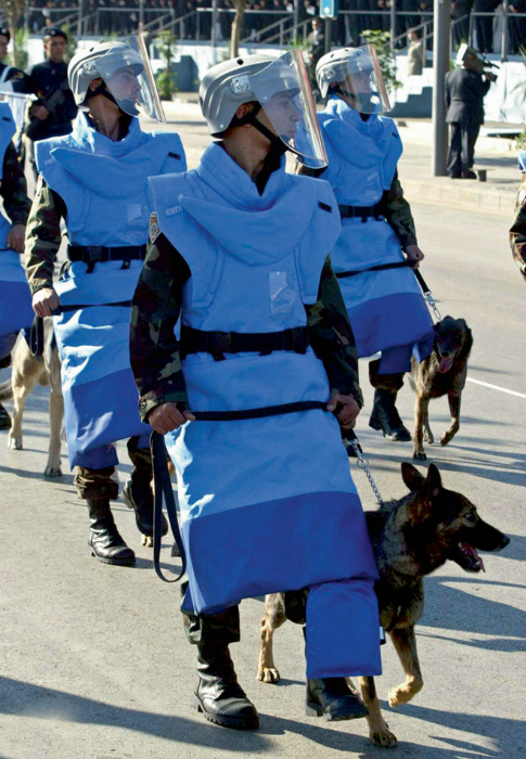 Ливанские солдаты-кинологи в синих защитных костюмах.