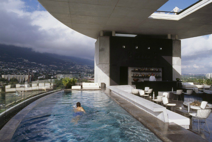Два бассейна с холодной и горячей водой разделенные баром на крыше отеля Habita Monterrey.