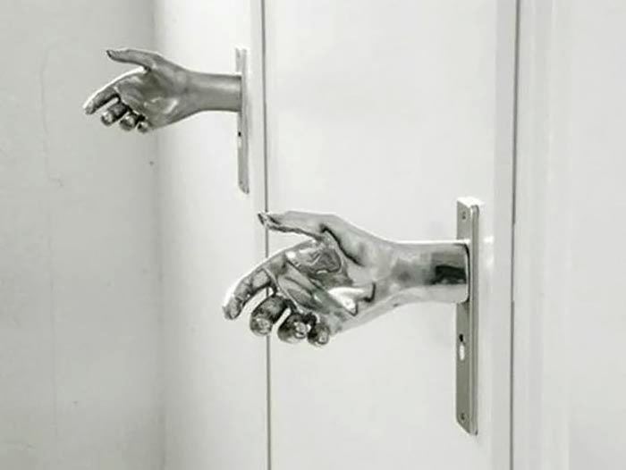 Дизайнерская дверная ручка в виде человеческой руки.