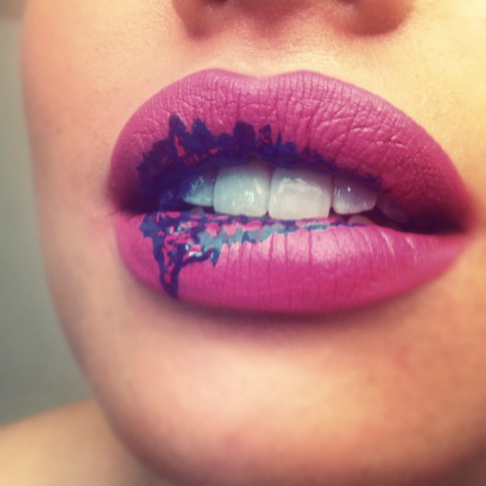 Оригинальный макияж губ: имитация синих подтеков на розовом фоне.