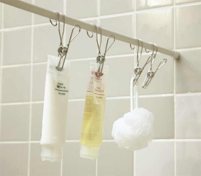 Шампуни, гели для душа и мочалки можно повесить на карниз для шторки в ванной.