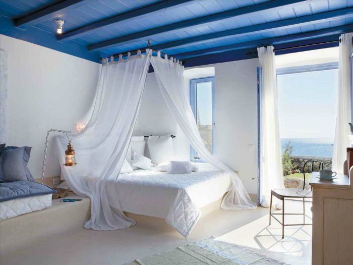 Светлая спальня с синим потолком.