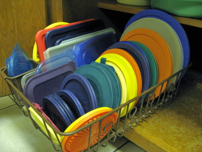 Хранение крышек на подставке для посуды.
