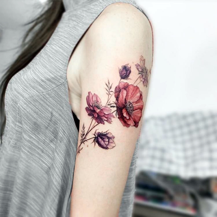 Татуировка с реалистичным изображением цветов.