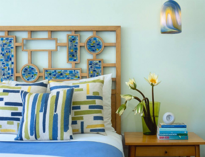 Замысловатая решетка из дерева, декорированная яркими элементами, сделает кровать стильной и оригинальной.