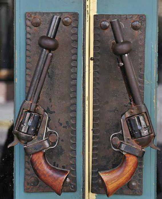 Дверные ручки в виде револьверов.