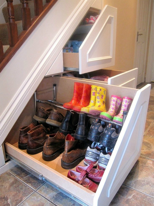 Хранить обувь или другие предметы, которые занимают много места, будет удобно в скрытом шкафу под лестницей.