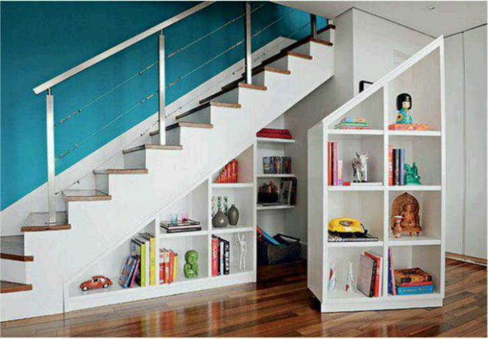 Чтобы пространство под лестницей не пропадало даром, можно оборудовать там несколько полочек для книг или других нужных вещей.
