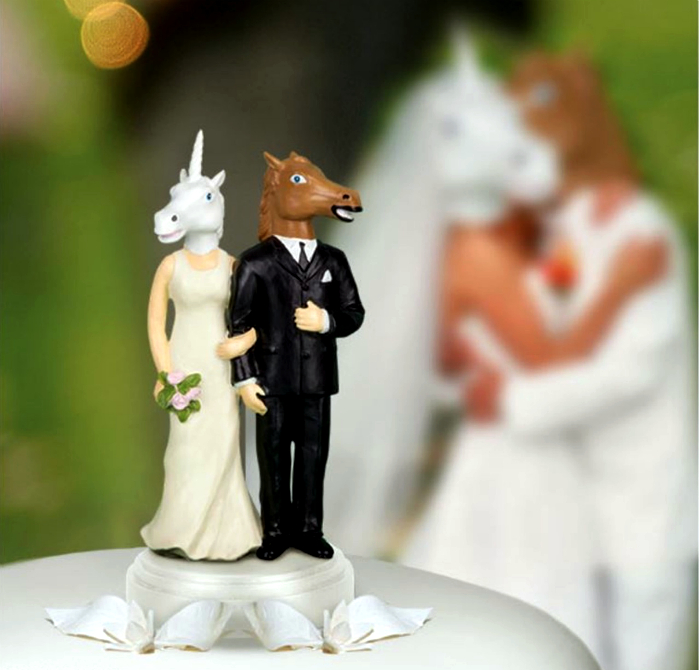 Свадебный торт, украшенный фигурками в виде невесты-единорога и жениха-лошади.