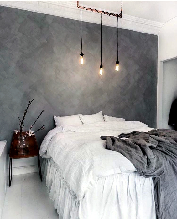 Стена в изголовье кровати, украшенная серыми фактурными обоями.
