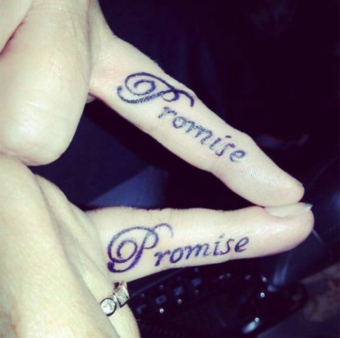 Татуировки со словом «Обещаю» на мизинцах мужчины и женщины.