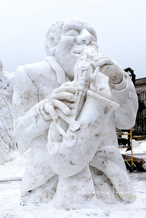 Снежная скульптура в виде уличного музыканта.